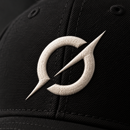 Close-up of the off-white embroidered JGT logo on the textured black fabric of a baseball cap.